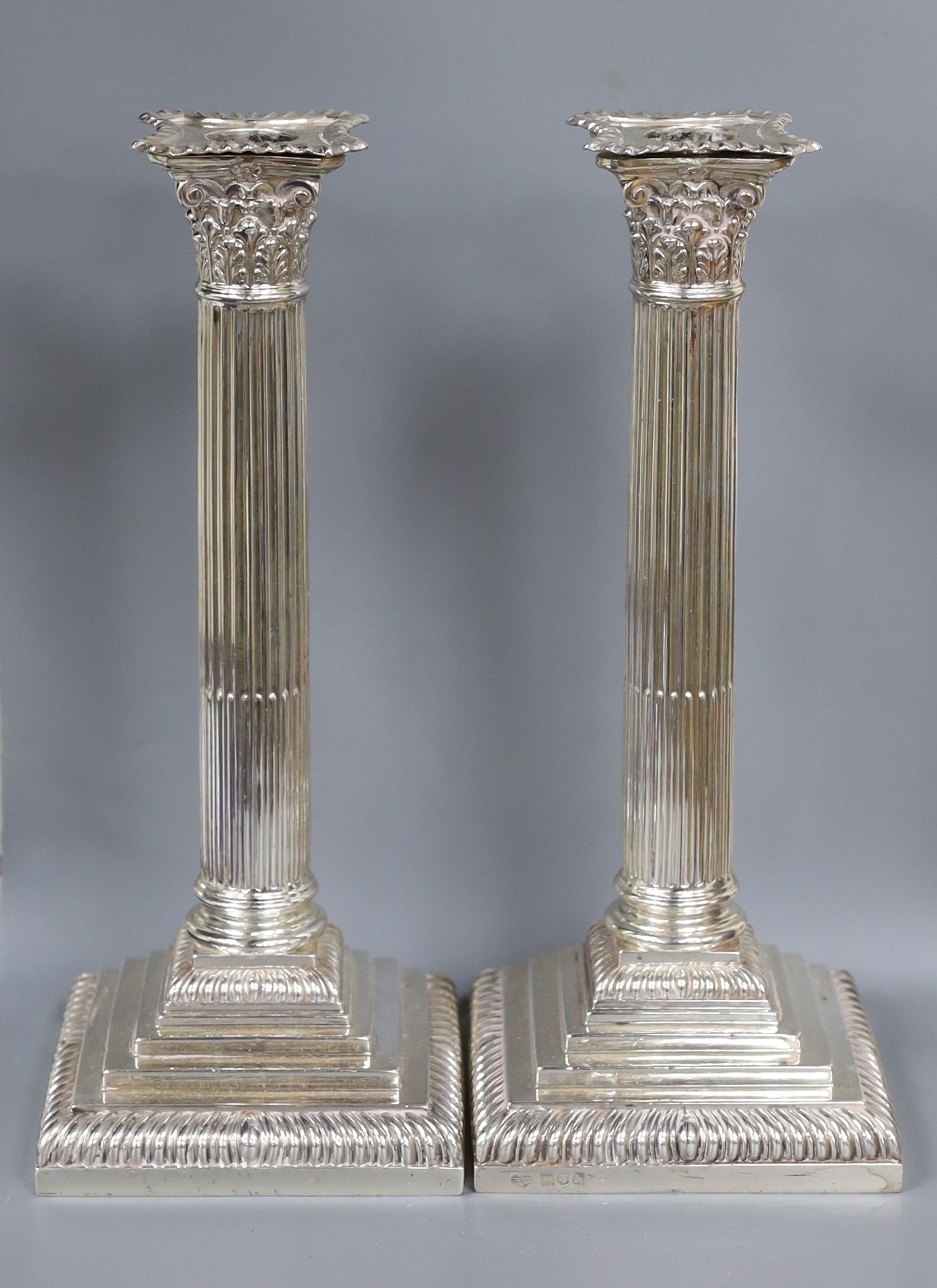 A pair of Edwardian silver Corinthian column candlesticks, Goldsmiths & Silversmiths Co Ltd, London, 1903, 27.4cm, weighted.